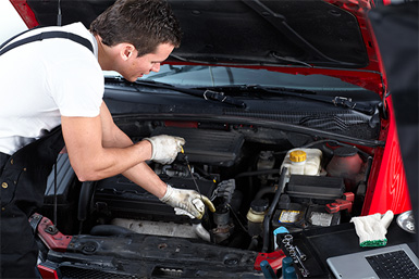 Mechanic servicing an engine under the bonnet